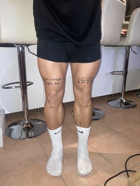 Unique Tattoos For Men Leg, Mens Gym Tattoos, Leg Tattoos Roman Numerals, Man Tattoo Ideas Leg, Minimal Thigh Tattoos Men, Leg Word Tattoo Men, Ice In My Veins Tattoo, Small Quad Tattoos For Men, Cross Shin Tattoo