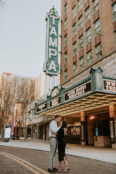 Bride in all black standing with groom in front of tampa theater sign Downtown Rooftop Engagement Photos, Downtown Tampa Elopement, Hyde Park Tampa Photoshoot, Tampa Theatre Photoshoot, In Town Photoshoot, Down Town Photoshoot Couples, Couples Photo Shoot Downtown, Engagement Photos Theatre, Editorial Downtown Engagement Photos