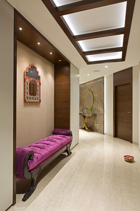 This space is typically characterized by the loose furniture setup which is sourced from a renowned furniture design brand from Delhi.  Taking this approach forward, the long narrow passage leading to the home, designed on ethnic lines for only the entrance, ensuring that the balance is maintained between the modern design and the promise to blend it with a dash of ethnic. Hence a wall mounted artwork of a Jharoka is placed in front of the beautiful ‘Sabyasachi’ range wallpaper. Modern Corridor, Hallway Stairs, Foyer Modern, Hall Interior Design, Modern Asian, Modern Marble, House Details, Hall Interior, 카페 인테리어 디자인