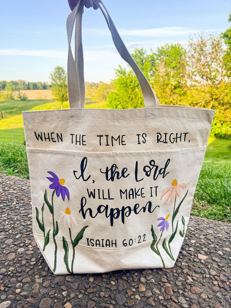 Handpainted and handlettered tote bag. Perfect for a Bible bag, book bag, or for carrying essentials! It has a rectangular shape with a large main pocket and two braided handles on top. Two more pockets are sewn onto the front of the bag, allowing for even more storage and organization. Dimensions: 16" x 18" x 6"  Handle Drop Length: 8" Content: 100% Cotton Color: Natural Diy Bag Painting Ideas, Tote Bag Painting Ideas Bible Verse, Church Tote Bag Ideas, Diy Christian Tote Bag Painting Ideas, Diy Bible Tote Bag, Christian Tote Bags Diy, Brown Bag Decorating Ideas, Bible Study Bag Totes, Bible Verse Tote Bag Painting