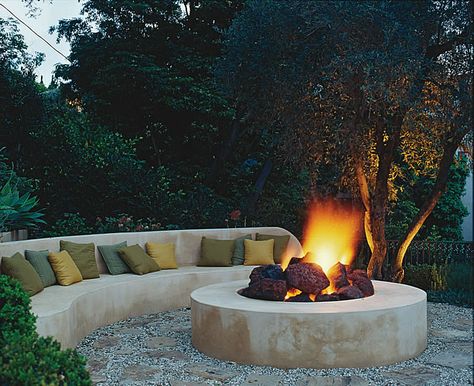 Designing with fire features: The fire sits in a 12-foot circle of flagstone and gravel, the same materials used for the path that winds up to this cozy hideaway. Rounded chunks of lava stone break up the sleek design giving the fire pit a more authentic, rustic feel. Photo by Tim Street-Porter. #gardendesign #autumn #firepit Fire Pit Gallery, Bonfire Pits, Sunken Fire Pits, Fire Pit Materials, Outdoor Fire Pit Designs, Chill Zone, Fireplace Garden, Fire Pit Seating, Concrete Fire Pits