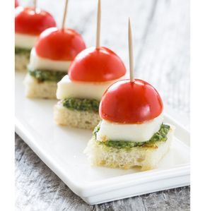 Graduation Party Appetizers You Can Eat in One Bite | Caprese Bites with Pesto: Homemade pesto is the key to this appetizer, which transforms the classic caprese sandwich into a bite-size treat. Grilling the rustic bread gives it a bruschetta-like taste, which pairs perfectly with the olive oil and garlic in the pesto. Skewer each bite with a toothpick to make them even easier to enjoy. #graduationparties #graduationpartyideas #appetizers #appetizerrecipes #realsimple Graduation Party Appetizers, Pesto Appetizers, Caprese Bites, Caprese Sandwich, Easy To Make Appetizers, Fingerfood Party, Homemade Pesto, Appetizer Bites, God Mat