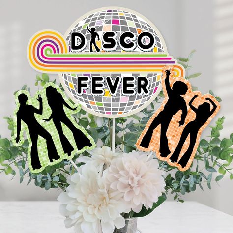 70's Disco Centerpiece Sticks includes 15 70's Disco table toppers in 3 different shapes, 15 table topper sticks, and stickers for easy assembly. Disco Fever party table decorations are the perfect addition to your party. 70's Disco Party Centerpiece Sticks Size 5 Disco Fever Table Toppers, 15.5"W x 8"H 5 Green Dancer Table Toppers, 5.5"W x 6"H 5 Orange Dancer Table Toppers, 5"W x 6.5"H The unique design and variety of pieces make this table decoration kit a memorable addition to any disco themed party. EASY PARTY DECORATION: 70's Disco table decorations can be used as centerpieces when attached to the included table topper sticks and inserted into a vase or floral arrangement. Add them to apothecary jars to accent your party candy buffet. Table toppers make a great addition to a photo boo Disco Centerpiece, Disco Table, Disco Fever Party, 1970s Party, Decades Party, 70s Party Theme, Decade Party, 70s Disco Party, 70's Disco