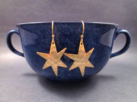 Raw brass hammered star pendants (23x28mm) on gold french hook ear wires. These earrings will dangle one and 1/2 inches from your ears.... (A happy buyer models her new earrings in the last picture.) Larger size is here: https://www.etsy.com/listing/14977971/larger-size-star-earrings-hammered-raw See more of my designs here: justEARRINGS.etsy.com The same earrings with hoop ear wires here: https://www.etsy.com/listing/71068275/star-earrings-hammered-raw-brass And please visit my sister~shops; ju Gold Dangle Earrings, New Earrings, Dope Jewelry, Fan Earrings, Funky Jewelry, Gold Earrings Dangle, Brass Jewelry, Brass Pendant, Dream Jewelry