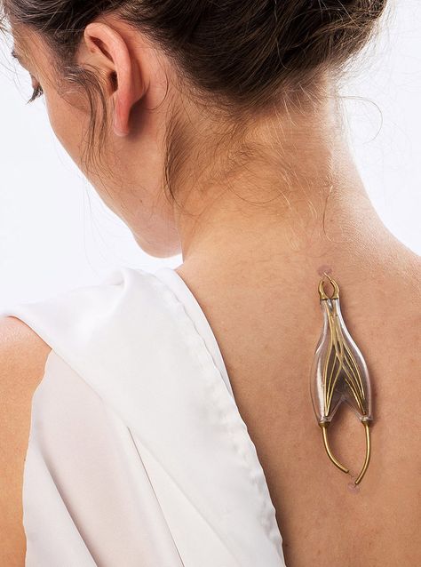 The ‘e-pulse conductor’ is a pendant without a chain, harvesting bioelectricity from the human body's neurological system, "plugged" into the spine via pincer interface. Speculative Design, Wearable Devices, Quirky Jewelry, Wearable Tech, Futuristic Fashion, Ex Machina, Nanotechnology, Wearable Device, Futuristic Technology