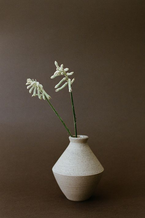 Echoing the striking silhouettes of Greek pottery, the Angular Ceramic Vase in Beige stands as a handcrafted marvel brought to life by skilled artisans in Europe. This multi-purpose vessel invites you to showcase its beauty by styling it with blooming buds or rustic branches. Due to its handmade nature, no two pieces are the same. Round Kitchen Table Styling, Angular Ceramics, Bud Vase Ceramic, Vase Product Photography, Ceramic Planters Indoor, Ceramic Flower Bowl, Ceramics Vase Ideas, Japandi Vase, Ceramic Vases Diy