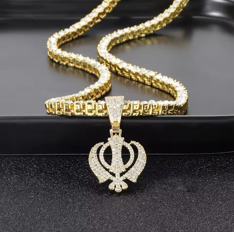 Expertly crafted with 18 K gold plated stainless steel and fully adorned with diamonds, the Khanda Necklace with Tennis Chain exudes timeless elegance and luxury. #khanda #khandanecklace #khandanecklacesparkle #sikhmodels #sikhwedding #sikhisim #smallbusiness Khanda Necklace, Tennis Chain, Sikh Wedding, Timeless Elegance, Tennis, 18k Gold, Gold Plate, Diamonds, Plating