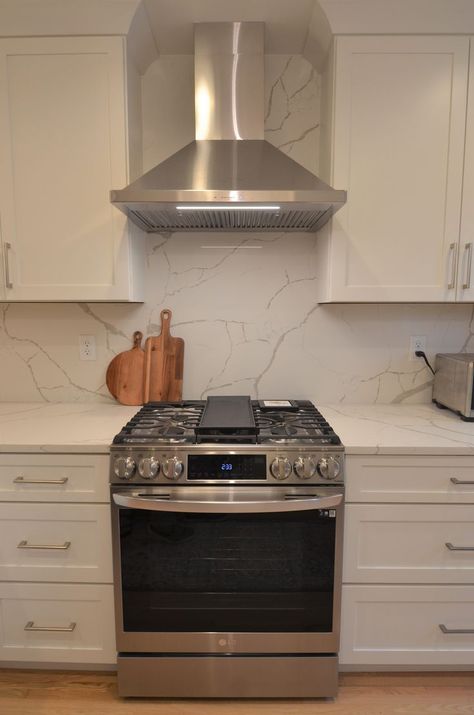 This small kitchen in Minneapolis features a large format quartz backsplash that matches the counter top.  This makes the kitchen feel larger and more open than it is.  Visually it is stunning. Great option for small kitchens. #smallkitchens #kitchenideas #quartz #quartzbacksplash Countertop Matching Backsplash, Kitchen Counter As Backsplash, Marble Counter And Backsplash Kitchen, Backsplash Countertop Same, Faux Marble Countertop And Backsplash, Counter Backsplash Kitchen, Marble Counter Top And Backsplash, Backsplash Same As Counter, Quartz Backsplash Behind Stove Only