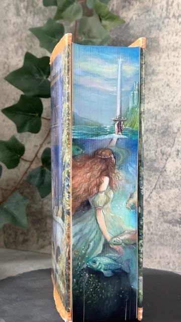 Hanna // fore-edge painter on Instagram: "Fore-edge painting on ‚Le Morte D‘Arthur‘ as a Commission. This old edition was impressive already without the painted edges. So it was a challenge to do the book justice. I think it was the longest process I ever had since I paint the edges of books and it’s so close to my heart now that it will be a bit harder than usual to give it away. But I am sure it will be in good hands! #foreedgepainting #lemortedarthur #kingarthur #ladyofthelake #excalibur #l Book Side Painting, Fore Edge Painting Diy, Book Spine Painting, Book Edge Painting Ideas, Book Edge Art, Painting On Book Covers, How To Paint Book Edges, Fore Edge Painting Books, Painted Edges Book