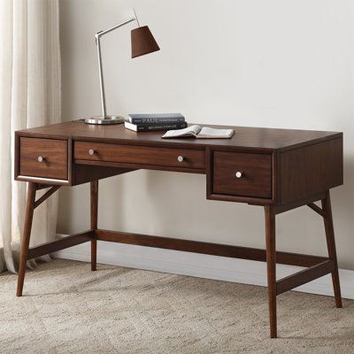 The design of the writing desk allows for the perfect placement within your home/office to accent your busy lifestyle. The brown finish combined with polished nickel knob hardware, drawer storage, and a mid-century-inspired profile, blend effortlessly to create this stylish table. | Corrigan Studio® Gavian Desk Wood in Brown | 30 H x 51.24 W x 24 D in | Wayfair Dark Office Desk, Minimal Study Table, Vintage Desk Ideas, Writing Desk Aesthetic, Dark Brown Desk, Brown Desks, Brown Wood Desk, Dark Desk, Walnut Writing Desk