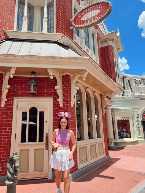 cute and simple outfit inspiration for walt disney world. girly and summer aesthetic. girl wearing a white lace skirt with a tank top and minnie moyse ears. drinking coffee on main street usa. Summer Outfits Disney, Magic Kingdom Outfit, Disney 2024, Disney World Outfits, White Lace Skirt, Main Street Usa, Simple Outfit, Drinking Coffee, White Skirt