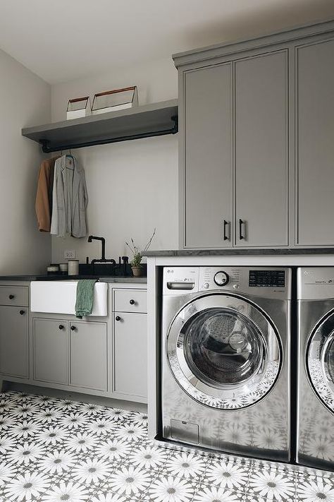 Charming gray laundry room features a silver washer and dryer placed on white and gray mosaic floor tiles and enclosed under gray cabinets finished with oil rubbed bronze pulls. Laundry Room Built In Cabinets, Grey Mosaic Tiles, Grey Laundry Rooms, Kate Marker Interiors, House Addition, Grey Mosaic, Basement Laundry Room, Basement Laundry, Laundry Room Cabinets