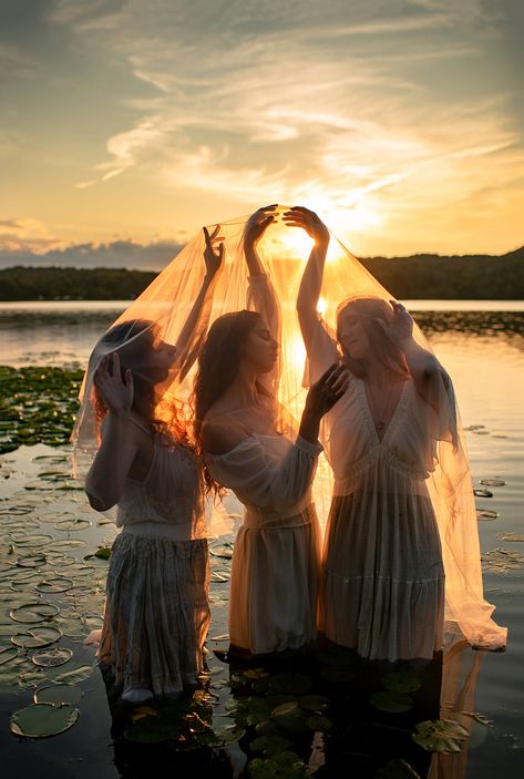 3 women dressed in white wade amidst a lake full of lily pads at sunset. Backlight Photography, Group Shoot, Lake Photoshoot, Color Mood, Water Nymphs, Monet Paintings, Fantasy Portraits, Blue Hour, Photography Inspo