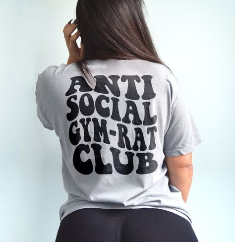 Anti social gym rat club shirt. Funny workout shirt for the gym! *Color shown is granite. Model is a US size 6 wearing a size large for a baggy fit.* UNISEX SHIRT - 100% USA cotton - Pre-shrunk so no need to worry about shrinkage - Comfort Colors Brand - Heavyweight material for a more comfortable fit - Relaxed fit. Order a size up for a more baggy feel. Unisex T Shirt Design, Gym Rat Shirt, Gym Merchandise Ideas, Gym Shirt Design, Gym Tshirt Design, Gym Clothing Brands, Gym Pump Cover, Gym Designs, Gym Pump