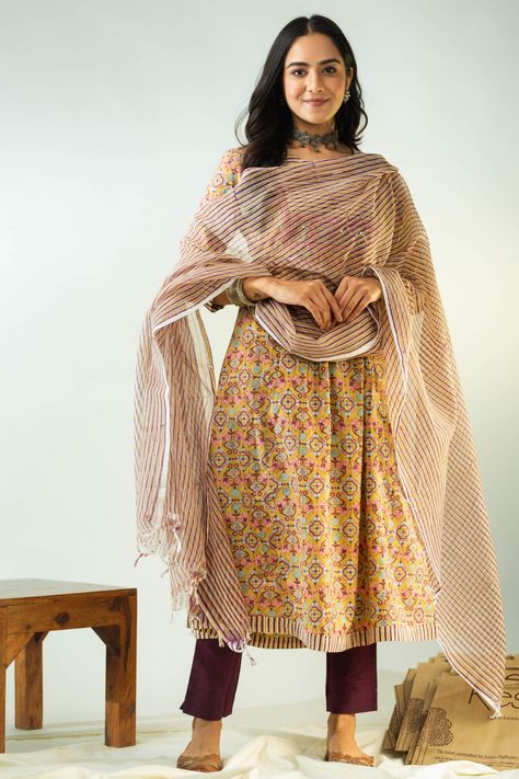 This beautiful cotton A-line kurta set comes with a matching Kota Doriya dupatta, making it a perfect outfit for any festive occasion. The kurta has a brown color with a handblock print design on the fabric, and the yoke is highlighted with shimmering sequins and a border. The round neck of the kurta has a V-cut, which adds a touch of elegance to the overall design. The kurta also features 3/4th sleeves, providing comfort and style. The kurta also has pockets on both sides, making it practical a Saree Jackets, Fancy Sarees Party Wear, Kurta Dress, A Line Kurta, Half Sleeve Shirts, Indian Textiles, Batik Prints, Top Pants Set, Kurta With Pants