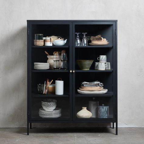 Enjoy a more refined take on the modern design aesthetic with this metal and glass display cabinet. This metal two-door china cabinet is designed with two glass panel door fronts, four shelves, and simple black metal framework, making it the perfect home for your favorite pottery, books, and other collected curiosities. The design is timeless and complements any range, color or texture so feel free to mix it up with both natural wooden colors, darker smoked stains, and bold colors from fabrics o Black Glass Cabinet, Luxury Storage, Dining Cabinet, Glass Panel Door, Glass Cabinets Display, Metal Display, Metal Cabinet, Tall Cabinet, Bookcase Shelves