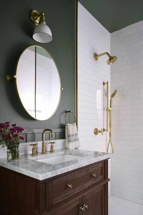 Nothing makes a space feel dynamic and luxe quite like high contrast! In this client's powder bath, we opted for the dark and dreamy Narragansett Green HC-157 by Benjamin Moore for the walls and ceiling. This allows the bright white shower tile to stand out while not dominating the space. Both the Narragansett Green and the white tile provide a beautiful backdrop for the brass pops in lighting and faucets. White Tile Green Paint Bathroom, Sage Green Powder Bathroom, Bathroom With Dark Green Walls, Dark Green Powder Bathroom, Green Bathroom Brass Fixtures, Green Inspired Bathroom, Bathroom With Dark Ceiling, Green Bathroom No Window, Bathroom White Tiles Green Walls