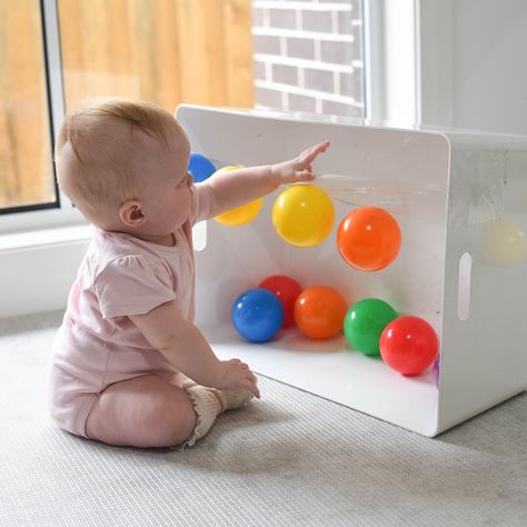 Exploring Sticky! 🖐🏼 Introducing Rory’s new favourite game! A length of sticky tape with balls stuck, for her to pull or smack off! 😋  Rory (6.5 months) is getting so confident with moving & reaching whilst sitting! This little invitation was so easy to set up & kept her busy, swatting balls before I even had a chance to stick them back up!  This would make a great tummy time activity too; allowing your Baby to shift body weight, balance & reach - all skills needed in preparation for crawling Baby Development Activities, Aktiviti Kanak-kanak, Baby Sensory Play, Baby Play Activities, Learning Games For Kids, Busy Boxes, Baby Activities, Baby Learning Activities, Baby Education