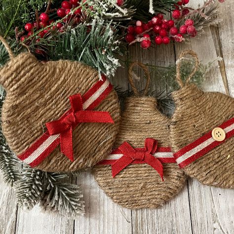 These are wood ornaments wrapped in twine with a bow on the front and a button on the back. The size is 4" x 4.75". Twine Ornaments Diy, Jute Ornaments, Recycled Ornaments, Homemade Xmas Gifts, Eco Friendly Christmas Decorations, Round Christmas Ornaments, Burlap Christmas Decorations, Rustic Christmas Crafts, Burlap Christmas Ornaments