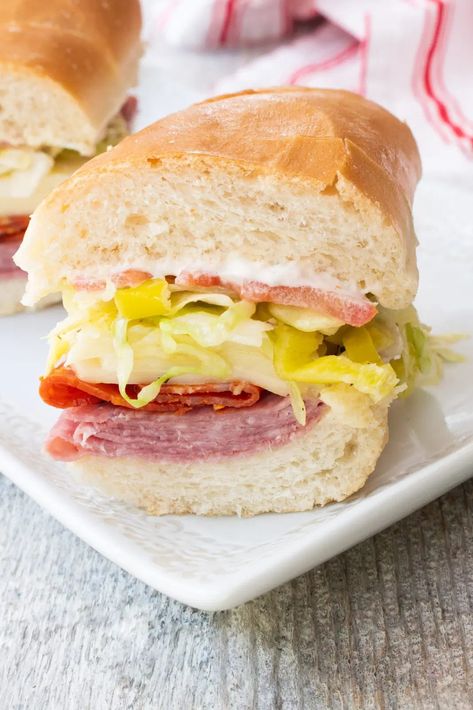 This Italian sub sandwich is crusty bread loaded with salami, pepperoni, and provolone cheese, then smothered with a vinaigrette dressed finely shredded lettuce and topped with thinly sliced veggies & peppers.  You are looking at Italian Sub Sandwich, Italian Grinder, Roasted Grape Tomatoes, Salami Sandwich, Braised Kale, Smoked Salmon Bagel, Mozzarella Sandwich, Sub Sandwich, Sandwich Sauces