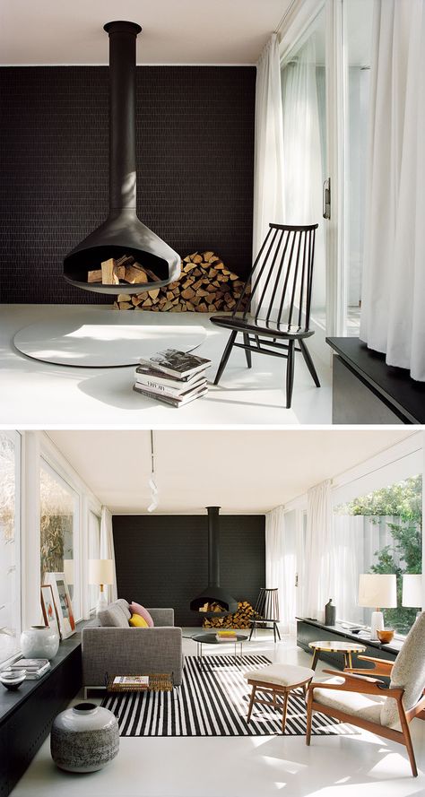 This modern living room features a hanging black fireplace, a black tile accent wall, modern furniture, light grey floors and a pale pink ceiling. Black Fireplaces, Modern Chic Living Room, Modern Living Room Black, Tile Accent Wall, Hanging Fireplace, Modern Family Rooms, Black Accent Walls, Living Room Drapes, Black Fireplace