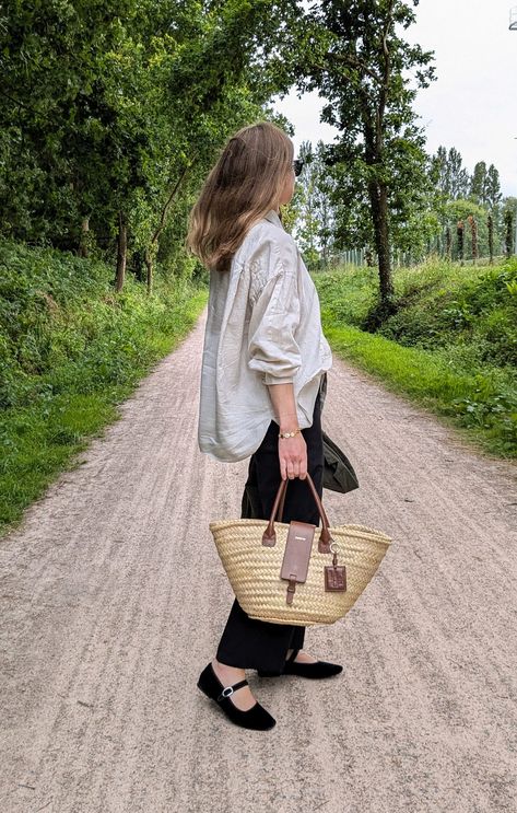 A woman stands on a path surrounded by trees on either side. She wears a white oversized shirt, black trousers, black Mary Janes shoes and a basket bag. Black Mary Janes Outfit, Oversized Summer Outfit, Mary Janes Outfit, Black Mary Janes, France Outfits, Northern France, Summer Vacation Outfits, Basket Bag, Three Days