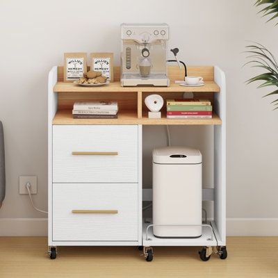 Organize your home office with this functional and stylish filing cabinet. It includes two drawers for letter- and legal-size files, and a space on the top with three open compartments for a printer, office supplies, and books. A convenient charging station gives this piece a modern twist, giving you three power outlets and two USB ports to keep your devices charged while you tackle your to-do list. We also love that the storage board can be used for your CPU or a paper shredder. This filing cab Rotating Bookcase, Printer Table, Shelves For Home Office, Printer Cabinet, Printer Shelf, Home Office White, Open Storage Shelves, Bookcase With Drawers, Rolling File Cabinet