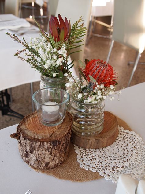 rustic stumps as wedding centrepieces with Australia native flowers Native Table Arrangements, Protea Wedding Table Decor, Aboriginal Wedding, Recycled Wedding Decorations, Bush Dance, Sept Wedding, Native Wedding, Recycled Wedding, Flower Table Decorations