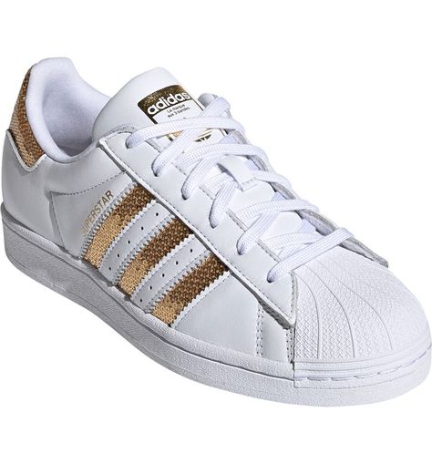 Free shipping and returns on adidas Superstar Sneaker (Women) at Nordstrom.com. Serrated 3-Stripes and a textured clamshell toe bring iconic detailing to a sneaker that's been a streetwear staple since it was introduced in 1969. Its low, lace-to-toe profile and herringbone tread kick up the heritage vibe. Adidas Superstar Gold, Lifestyle Shoes, Baskets Adidas, Adidas Sneaker, Unisex Shoes, Adidas Superstar Sneaker, Womens Sneakers, Adidas Sneakers, Shoe Boots