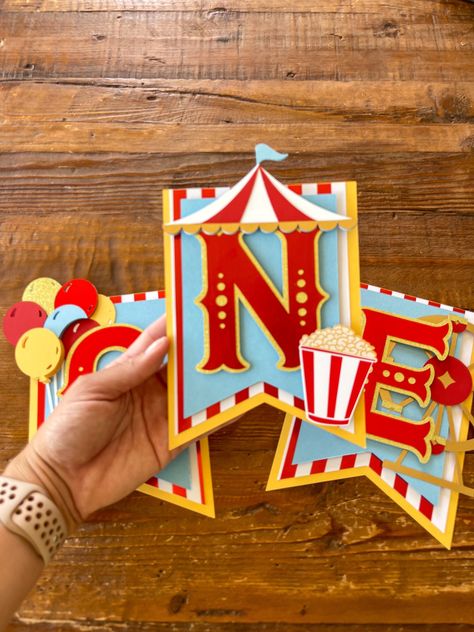 "Circus High Chair Banner Celebrate your little one with this beautifully handcrafted circus highchair banner.  This highchair banner is handcrafted with premium cardstock. It measures at 18 in wide.  My estimated shipping time may not be accurate. Whatever date is listed under \"Personalization\" is the earliest date I'm taking orders for. It is very important that I have your date! If no date is left (or it is farther out) your order will ship closer to my max shipping time, in which case the Circus Birthday Banner, Diy Circus Decorations, Carnival Decorations Ideas, Carnival Birthday Party Decorations, Circus Theme Decorations, Circus Theme Party Decorations, Circus Party Decor, Carnival Banner, Circus Banner