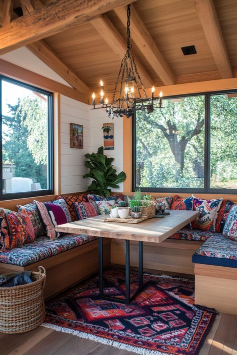 Cozy corner with a wooden table, colorful patterned cushions, and a chandelier, overlooking lush greenery. Breakfast Nook Corner, Farmhouse Breakfast Nook, Southern Front Porch, Nook Inspiration, Farmhouse Breakfast, Organic Modern Bathroom, Breakfast Nook Ideas, Mismatched Chairs, Nook Table