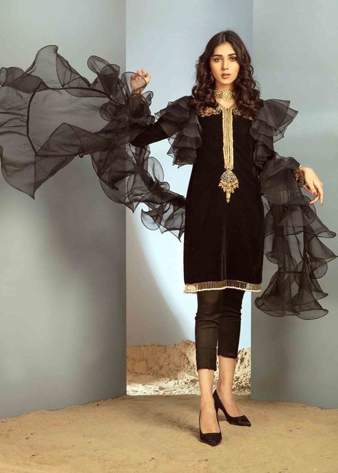 Include: Shirt Pants Dupatta Addons: Mask [+PKR 1670] Fabric: Shirt: Velvet Pants: Cotton Silk Dupatta : Organza Color: Black Work Technique: Embellished Description: This Beautiful, elegant Jet Black Straight velvet Silhouette is embellished with beautiful handwork of stones kora and nakshi on neckline styled with organza frills on arm holes to give it a chic look paired up with straight capri pants. To make this statement piece more chic it is styled with organza Frill dupatta This is a 3 Piec Velvet Short Kurti, Frill Dupatta Designs, Frill Dupatta, Ruffle Dupatta, Plazzo Suits, Black Velvet Shorts, Velvet Short, Short Kurti, Kurtis With Pants