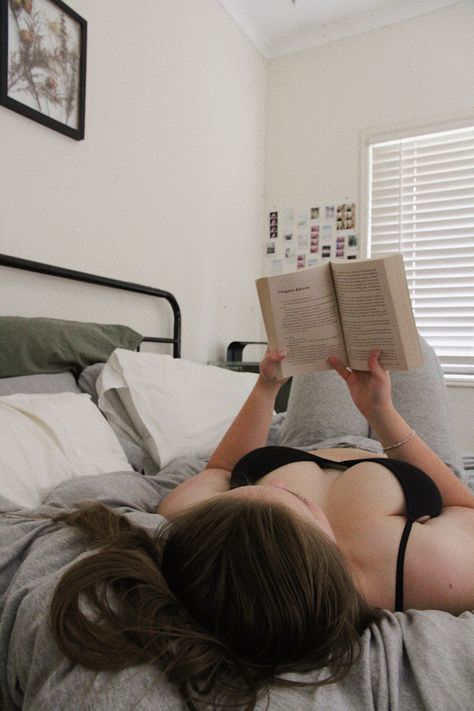 A girl with a black bra and grey sweat pants holding a book is laying down with her back down on a bed reading a book. the bed has a grey quilt with white, green and grey pillows Selftimer Photography Ideas, Instagram Self Portrait Ideas, Simple Self Portrait, Self Portrait Aesthetic, Self Portrait Poses With Book, Self Portraits Ideas, Self Portrait Ideas At Home, Self Portrait In Room, Self Photography Ideas At Home