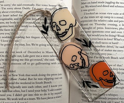 "Looking for a stylish and unique Halloween bookmark that shows off your personality? Look no further than this Boho Skull resin acrylic bookmark! Each bookmark is handmade from durable acrylic resin, with a gorgeous gold glitter background and a chic twine ribbon.  All items are handmade and made to order.  These handmade Halloween bookmarks make a great gift for any book lover in your life. Order yours today and add a little flair to your reading! Perfect addition to your 2023 \"boo box\" ** C Spooky Bookmarks Diy, Diy Acrylic Bookmarks Cricut, Creative Bookmarks Design Ideas, Halloween Resin Crafts, Acrylic Bookmark Ideas, Goth Bookmark, Skull Bookmark, Spooky Bookmarks, Halloween Bookmarks