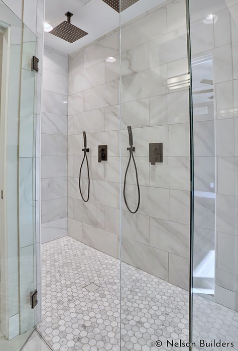 The master shower features two shower heads and a curbless design, for a clean, modern aesthetic. Master Shower Dual Heads, Two Shower Heads On Same Wall, Tile Shower Double Head, Shower 2 Heads, Master Bath Dual Shower Heads, Bathroom Shower Double Head, Shower Remodel Two Shower Heads, Dual Rain Shower Master Bath, Two Showers In One Bathroom