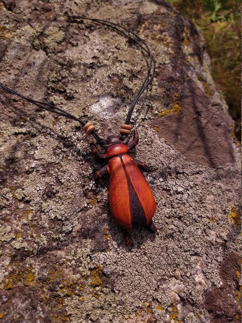 "Wooden beetle pendant made from buckthorn wood. Cardinal beetle pendant coated with matt tung oil. It turned out very peculiar, on the sketch it was seen differently, although in my work the final version often differs from the sketch. Carved beetle pendant is very noteworthy due to the bright buckthorn color and the contrast created by burning. The shape is strange, but this entomological decor as a whole seems to be beautiful, I think. To give this pendant a boho style, it was hung with waxed Sketch It, Tung Oil, Wood Cover, Boho Style Jewelry, Style Jewelry, Wooden Beads, Wood Carving, Boho Style, Boho Fashion