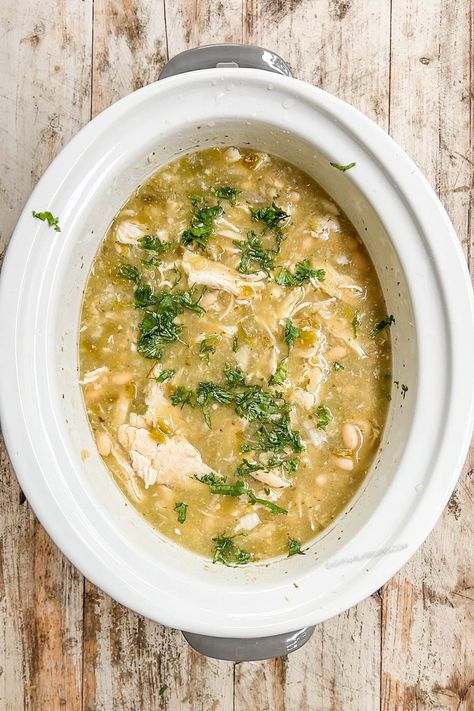 Break out the slow cooker for this easy Salsa Verde Soup recipe with chicken! This Crock Pot chicken soup couldn’t be easier to make. Layer chicken, onions, garlic, seasonings, white beans, and and a jar of flavorful salsa verde in your slow cooker, turn it on, and go about your day. Later on, you’ll come home to delicious Salsa Verde Chicken Soup, simmering and ready to top with sour cream, cheese, and tortilla chips. Yum! Chicken Verde Soup Crock Pot, Chicken Verde Soup, Salsa Verde Soup, Salsa Verde Chicken Soup, Crock Pot Chicken Soup, Soup Recipe With Chicken, Easy Salsa Verde, Verde Soup, Chicken Verde