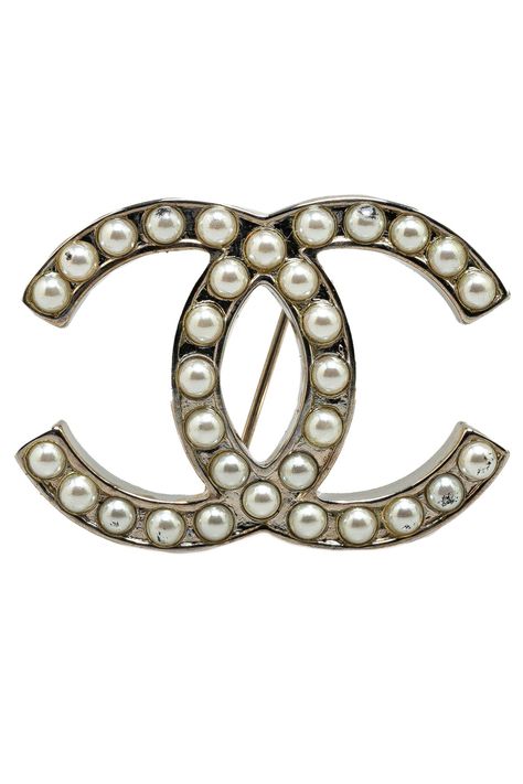 De CC Faux Pearl Brooch van Chanel is een luxe vintage accessoire met een zilverkleurig metalen lichaam en faux parels. Deze broche in de iconische dubbele C-vorm heeft een elegante glans en verfijnde uitstraling. De combinatie van het klassieke logo met parelachtige elementen zorgt voor een tijdloze charme, perfect voor elke outfit. Het item vertoont tekenen van gebruik, waaronder krassen en vlekken, wat bijdraagt aan de authentieke vintage look. Deze broche is 4.00 cm breed en 3.00 cm lang. Een statement piece dat de essentie van Chanel belichaamt. Authenticatieprocessen zijn strikt en certificaat van echtheid kan op verzoek worden geleverd. Staat van het item is beoordeeld met de letter(s) B+.