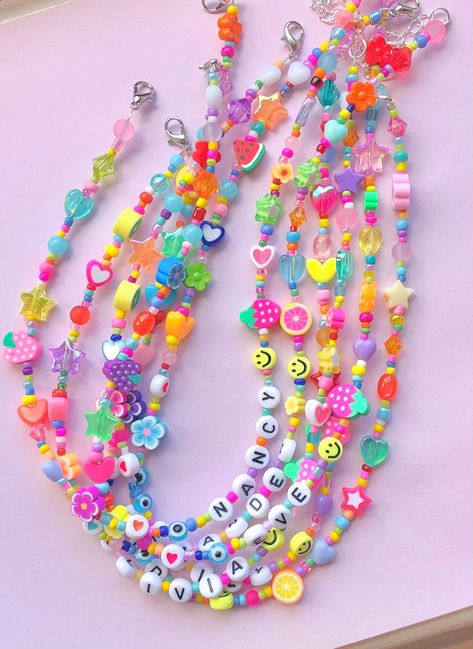 These quirky mismatched necklaces feature multi coloured glass seed beads with random cute charms, such as; stars, hearts, smileys, fruits, flowers, evil eyes & more! Any name/s or word/s up to 12 letters can be added to this necklace, perfect as a personalised gift. Each and every necklace is unique, as they are all made to order. The length is also customisable, just choose your desired length from the drop down box. You can also add an extender chain, so you can wear this necklace at diff Modern Beads Jewelry, Mismatched Necklaces, Cute Beaded Necklaces, Beaded Name Necklace, Kalung Manik-manik, Cute Beads, Colourful Jewellery, Necklace Y2k, Clay Bead Necklace