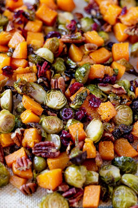 Roasted brussel sprouts and butternut squash are coated with a sweet maple glaze and tossed with toasted pecans and sweet dried cranberries. This healthy side dish is a great gluten free and dairy free option for Thanksgiving. Honey Roasted Butternut Squash With Cranberry And Feta, Butternut Squash Brussel Sprouts Roasted Maple, Roasted Brussel Sprouts And Sweet Potato Thanksgiving Recipes, Butternut And Brussel Sprouts, Maple Soy Glazed Roasted Brussels Sprouts And Butternut Squash, Vegan Thanksgiving Brussel Sprouts, Roasted Brussels And Butternut Squash, Squash And Brussel Sprouts Roasted, Butternut Brussel Sprout Recipes