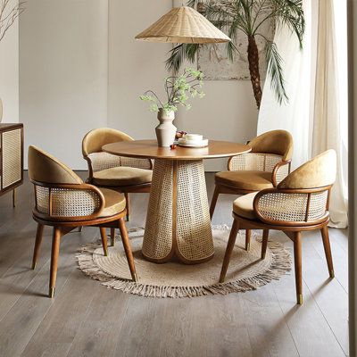 Enhance your dining experience with our 4-person dining table set in brown. This modern and minimalist set features a round tabletop made from ash wood, exuding elegance, and simplicity. The unique craftsmanship of the woven rattan table legs adds a touch of natural charm to your dining space. The set includes four solid wood chairs, featuring intricately woven rattan backrests for added style. The chairs are designed with comfort in mind, with soft velvet upholstery on the seats and foam fillin Round Garden Table, Coffee Table With Chairs, Rattan Dining Table, Rattan Dining, Rattan Table, Adjustable Height Table, Wood Table Top, Adjustable Table, Pedestal Dining Table