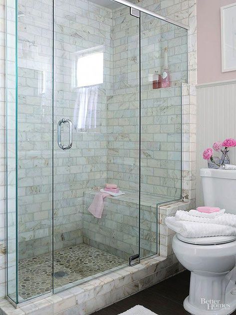 walk-in shower that enhances a usefulness and beauty. This shower stands out in a simply furnished bath, thanks to its distinctively tiled walls and river-rock-tiled floor that are easily seen through a frameless glass shower enclosure. The glass enclosure stair-steps up a marble frame, highlighting the shower bench and a toiletry shelf that aligns with the beaded-board wainscoting's upper trim. #BathroomShower Makeover Kamar Mandi, Små Rum Lidt Plads, Small Bathroom With Shower, Bad Inspiration, Master Bath Remodel, غرفة ملابس, Small Bath, Basement Bathroom, Bathroom Redo