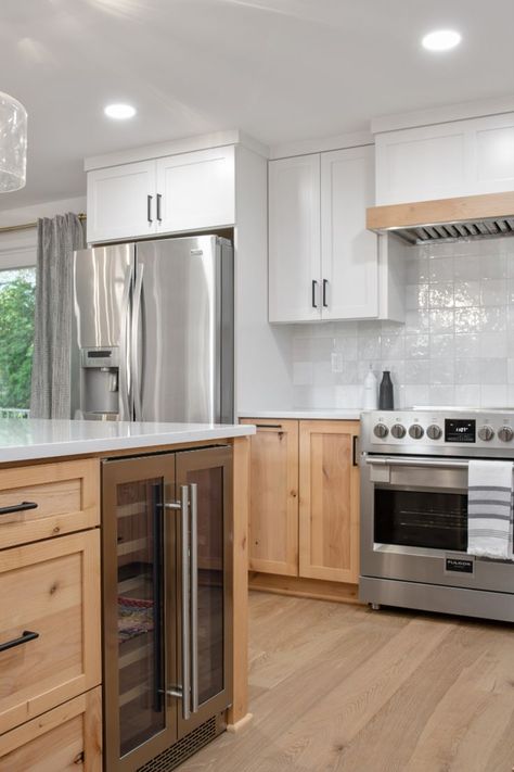 A mix of Knotty Alder lower cabinets and painted Wider White (SW 7014) upper cabinets give this Portland kitchen remodel an updated look. Matte Black accents pop against the subtle color palette. 42 Inch Upper Cabinets Kitchen, White Oak And Black Kitchen Cabinets, Wood Bottom Cabinets White Upper, Two Tone Kitchen Cabinets Wood And White, Two Tone Kitchen Cabinets Wood, White Upper Cabinets Wood Lower, Knotty Alder Kitchen Cabinets, Alder Wood Kitchen Cabinets, Knotty Alder Kitchen