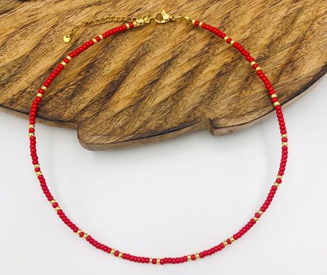 Experience the essence of timeless elegance with this handmade minimalist bead necklace. A bold statement in deep red, subtly complemented by the sparkle of gold or silver. This necklace radiates self-confidence in its simplicity. The red beads are a bold expression of style, while the gold or silver accent adds some sophistication, like a sparkling gemstone in the sunlight. Let yourself be pampered with the timeless beauty of this necklace. Stainless steel closure (durable, high quality and doe Red Beaded Necklaces, Orange Necklace, Red Beads, Burgundy And Gold, Miyuki Beads, Red Bead, Silver Accents, Red And Gold, Deep Red