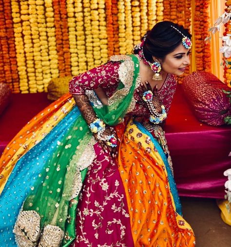 Photo via Aynaa | bride wearing beautiful multicoloured lehenga for her mehendi day | lehenga with multicoloured plates and embroidery work | marigold background decor | that bridal mehendi though | #mehendi #outfit #mehendioutfit #mehendidesigns #outfits #outfitoftheday #outfitideas #outfitinspiration #lehenga #lehengablousedesigns #embroidery #floraljewellery #indianbride #indianbridesinstagaram #indianbrideslike #henna #hennamehndi Mehndi Ceremony Outfit For Bride, Dress Colour Combination Ideas, Mehendi Looks For Bride, Mehndi Ceremony Outfit, Dress Colour Combination, Multicoloured Lehenga, Marigold Background, Lehenga For Mehendi, Presentable Outfits