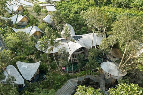 We soar high above the entire Ulaman Eco Retreat complex and grounds for a birds-eye view revealing its scale and grandeur. Established in 2020 and located in Bali between forest, rice fields and river, the Main House was created and designed in collaboration with Inspiral Architects in a 5 month project that used 22 local craftsmen. Eco Retreat, Bamboo Construction, Rice Field, Rice Fields, Birds Eye View, Maine House, Birds Eye, Patio Umbrella, Architects