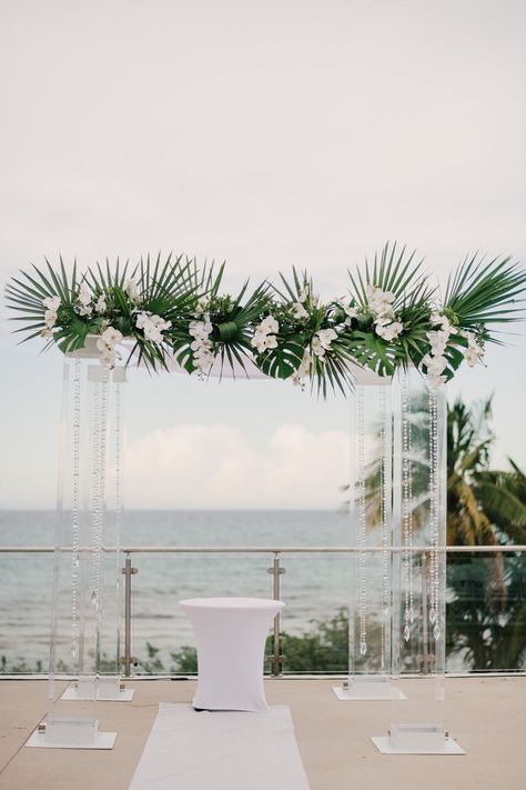 All white oceanfront wedding ceremony with tropical floral altar at Fontainebleau in Miami Beach, Florida. Brought to life by Photographer- Evan Rich, Florist- Landy’s Flowers By Gerardo and Bridal Gown Designer- Pronovias. Tropical Wedding Ceremony Arches, Beach Flower Arch Wedding, Flower Arch Beach Wedding, Beach Wedding Arch White Flowers, Grounded Floral Arches Beach, White Wedding Ceremony, Oceanfront Wedding, Modern Tropical, Designer Bridal Gowns