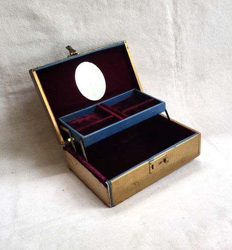 Vintage jewelry box from the 1950s or 1960s.  The outside is a gold faux reptile vinyl.  I believe the side is metal. Inside lining is dark burgundy.  Oval mirror.  One side is missing the faux reptile vinyl.  Normal vintage wear.  Look close and zoom on pics. 10 3/8 x 7 3/8 in 3 1/2 in tall Check out my handmade clothing at kissmyattitude.etsy.com Vintage Box Aesthetic, Adelaide Core, Necklace Organization, Art Deco Jewelry Box, Interiors Aesthetic, Victorian Jewelry Box, Layer Jewelry, Jewelry Box Vintage, Antique Jewelry Box