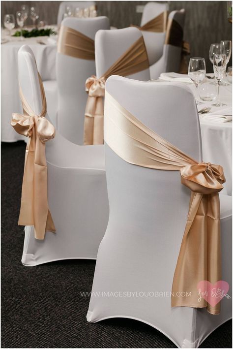 Cover Chairs For Wedding, Chair Covers With Sash, White And Gold Chairs Wedding, White Covered Chairs Wedding, Covered Wedding Chairs, Chair Decor Ideas Wedding, Chair Sash Tie Ideas, White Chair Covers With Gold Sash, Wedding Guest Chair Decor