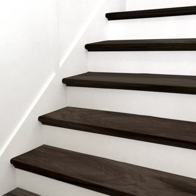 With modern, steely-grey hues and light knots and graining, Stair Tread Luxury Vinyl Tile adds style and elegance to a space. With MSI's Stair Tread, installation is easy, saving you time. There is no need to join a nose to a flooring plank, no join lines or gaps, and the finished look is professional and high-end. Use this gorgeous wood-look stair tread in the kitchen, living room, bathroom, or basement to create a seamless transition from floor to stairs. | MSI Luxury Vinyl Stair Tread Eased E Dark Wood Stairs With Runner, Lvp Flooring On Stairs, Vinyl Plank Stairs, Vinyl Plank Flooring On Stairs, Black Painted Stairs, Vinyl Stair Treads, Stairs Colours, Wood Stair Treads, Basement Finish